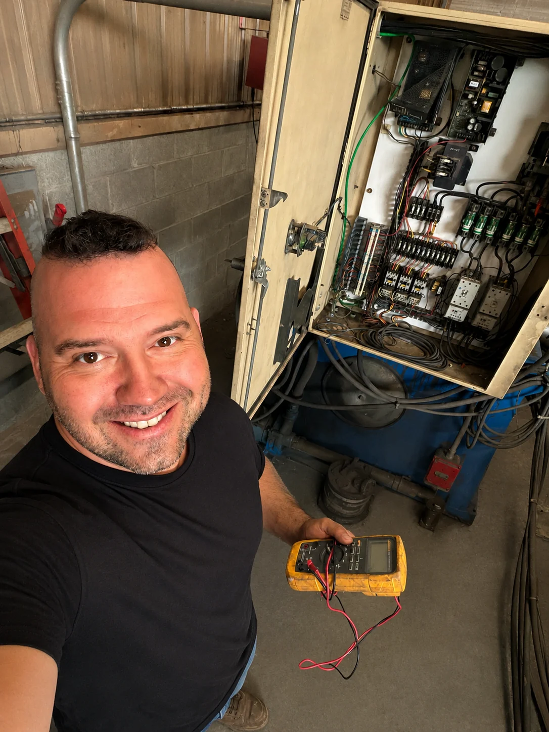 Brandon Hickman troubleshooting industrial electrical equipment with a multimeter